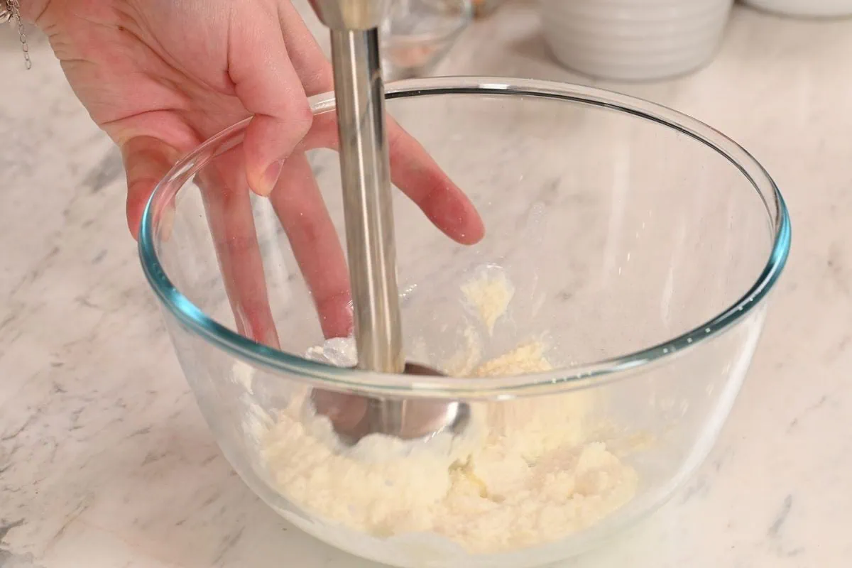 Lemon Cottage Cheese Protein Bars 5 Blending cottage cheese with an immersion blender until smooth for lemon cottage cheese protein bars.