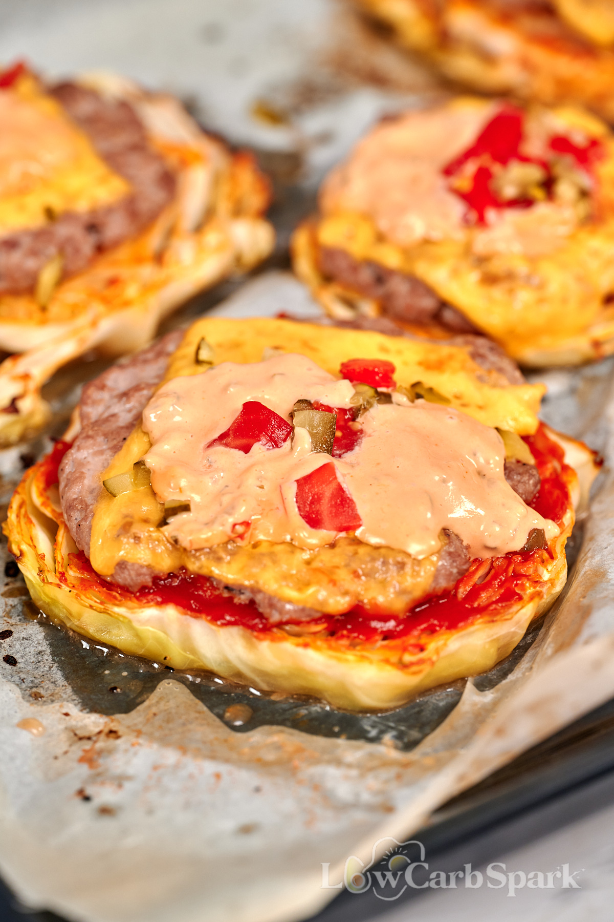 Cabbage Cheeseburgers 1 Cabbage cheeseburger topped with melted cheese, pickles, tomatoes, and creamy burger sauce on a roasted cabbage slice.