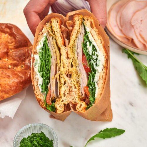 Cottage Cheese Psyllium Buns 15 Close up of a cottage cheese psyllium bun sandwich with turkey, arugula, tomato, and creamy filling.