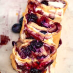 Sliced high protein cottage cheese blueberry roll filled with creamy cheese and juicy blueberry filling.