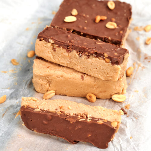 Cottage Cheese Snickers Bars 17 Stack of high protein cottage cheese Snickers bars with a creamy peanut butter layer and chocolate peanut topping.