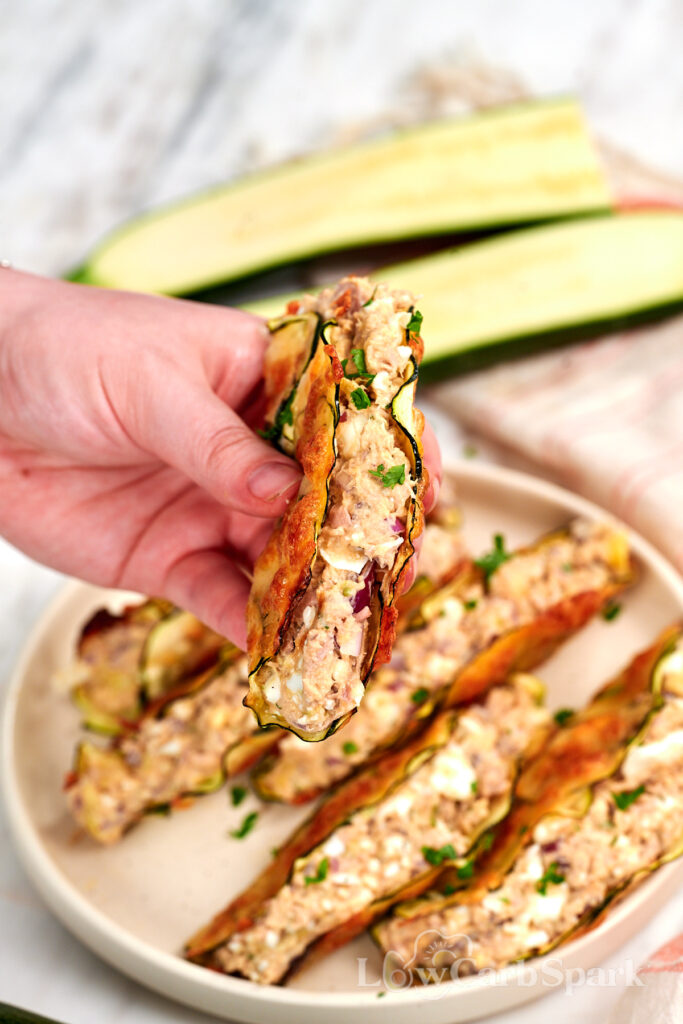 High-Protein Tuna Avocado Zucchini Tacos 13 Hand holding a High Protein Tuna Avocado Zucchini Taco filled with creamy tuna, avocado, red onion, and herbs.