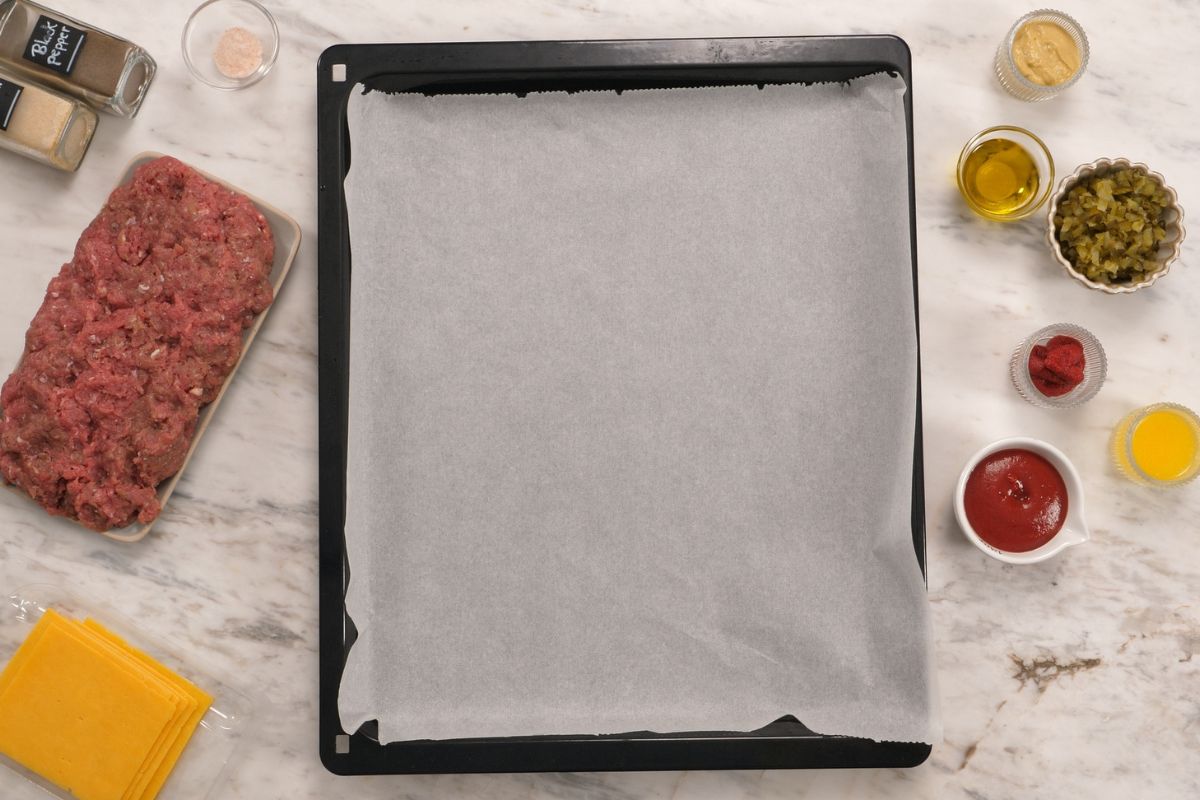 Cabbage Cheeseburgers 3 Parchment lined baking sheet ready for assembling homemade cabbage cheeseburgers.