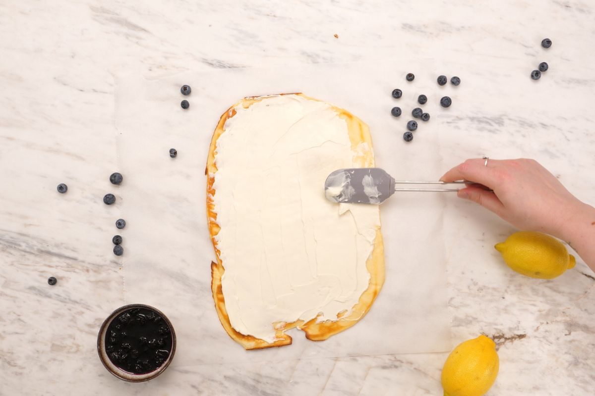 Cottage Cheese Blueberry Roll 8 Spreading cream cheese evenly over the baked cottage cheese roll base before adding the blueberry filling.