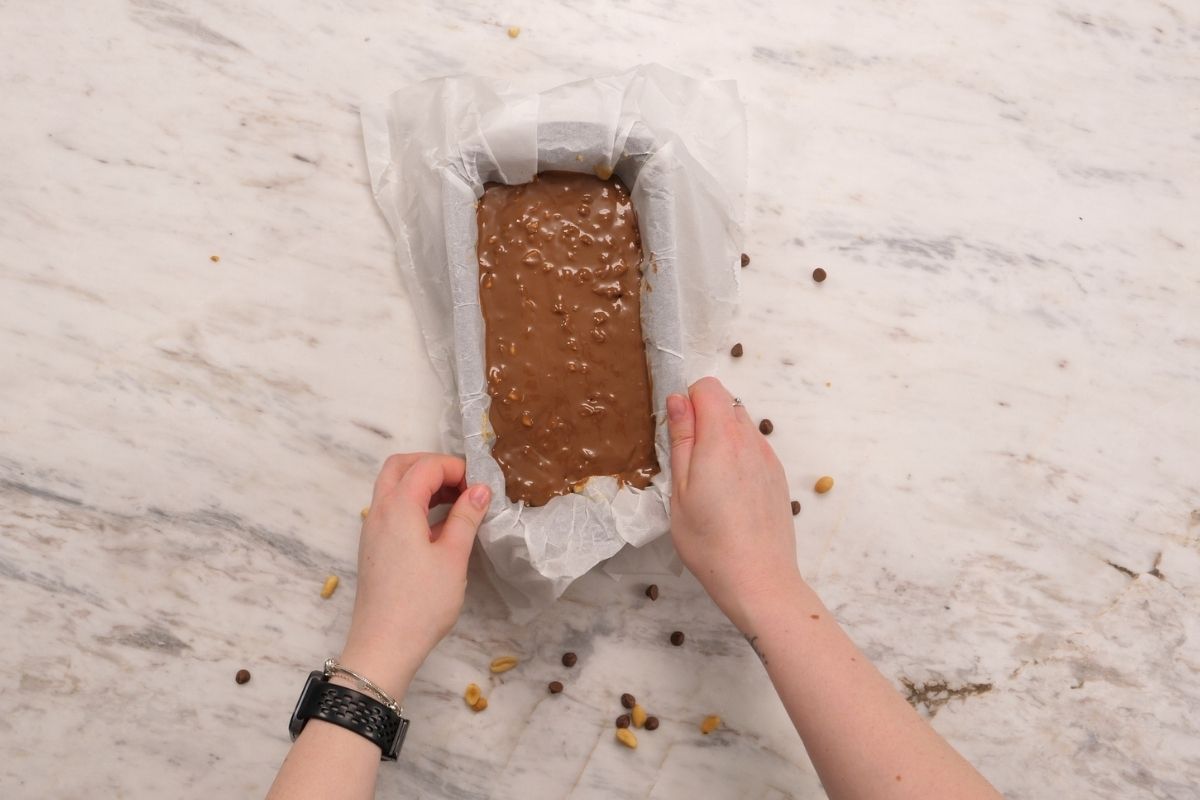 Cottage Cheese Snickers Bars 13 Chocolate topped cottage cheese Snickers bar mixture in a parchment lined loaf pan before chilling.