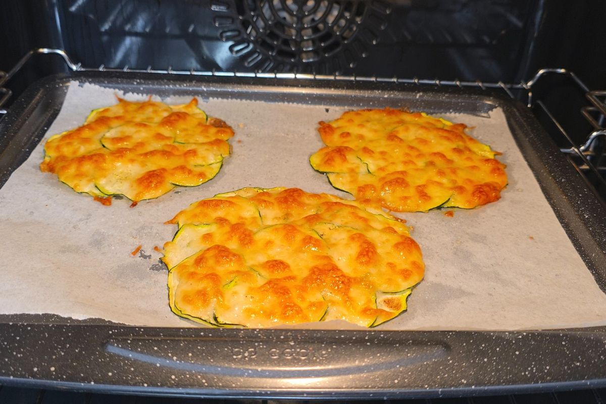High-Protein Tuna Avocado Zucchini Tacos 9 Golden baked zucchini cheese taco shells on a parchment lined baking sheet.