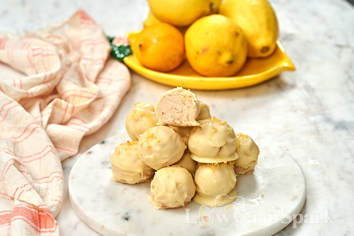 Lemon Cottage Cheese Truffles 10 Lemon cottage cheese truffles coated in white chocolate and topped with fresh lemon zest on a marble serving board.