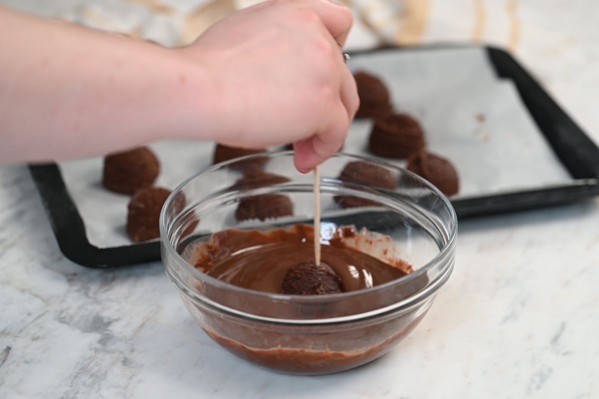 Chocolate Cottage Cheese Truffles 10 Dipping a chocolate cottage cheese truffle into melted chocolate.