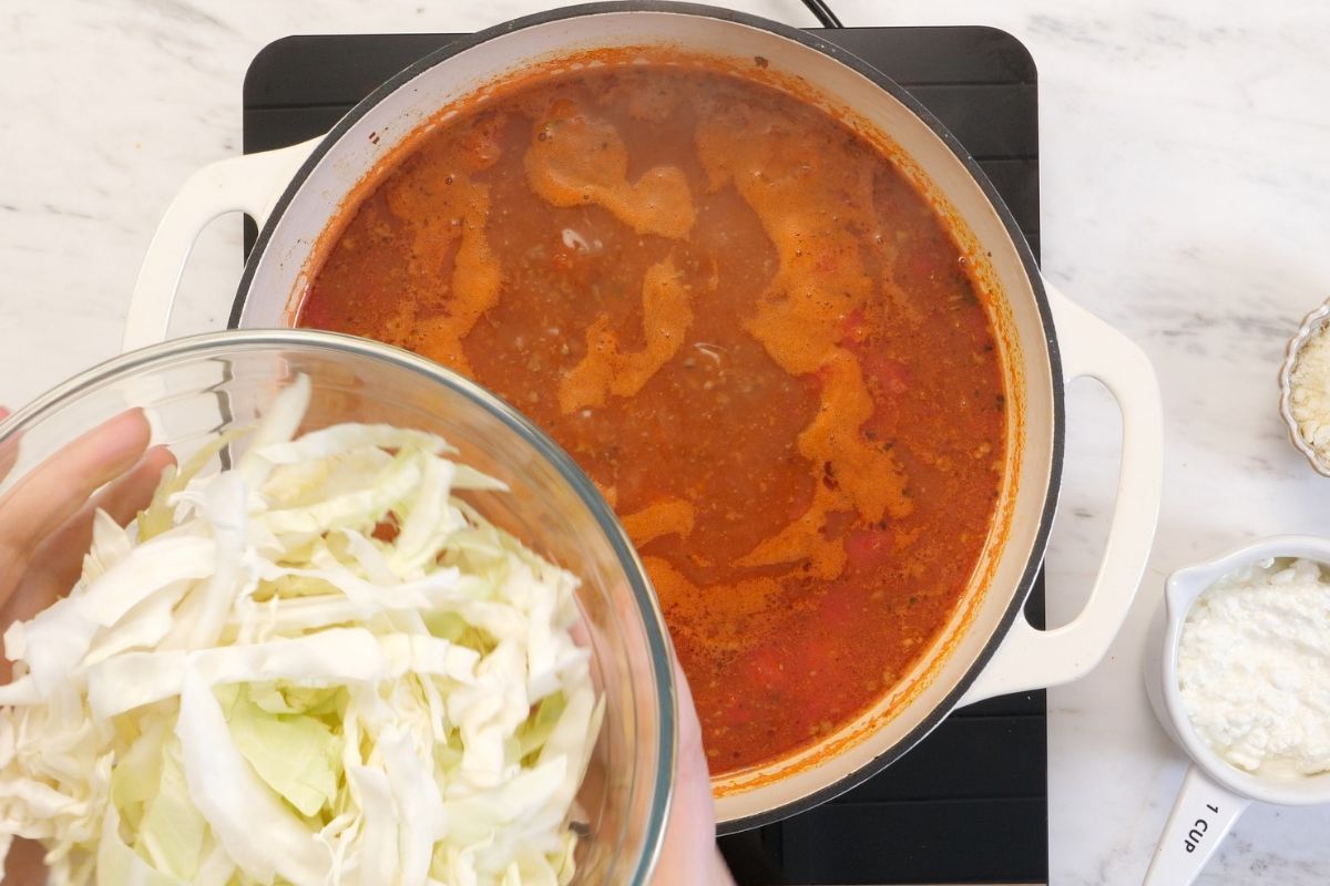 High-Protein Cabbage Lasagna Soup 8 Adding chopped cabbage to the simmering tomato and ground beef soup.