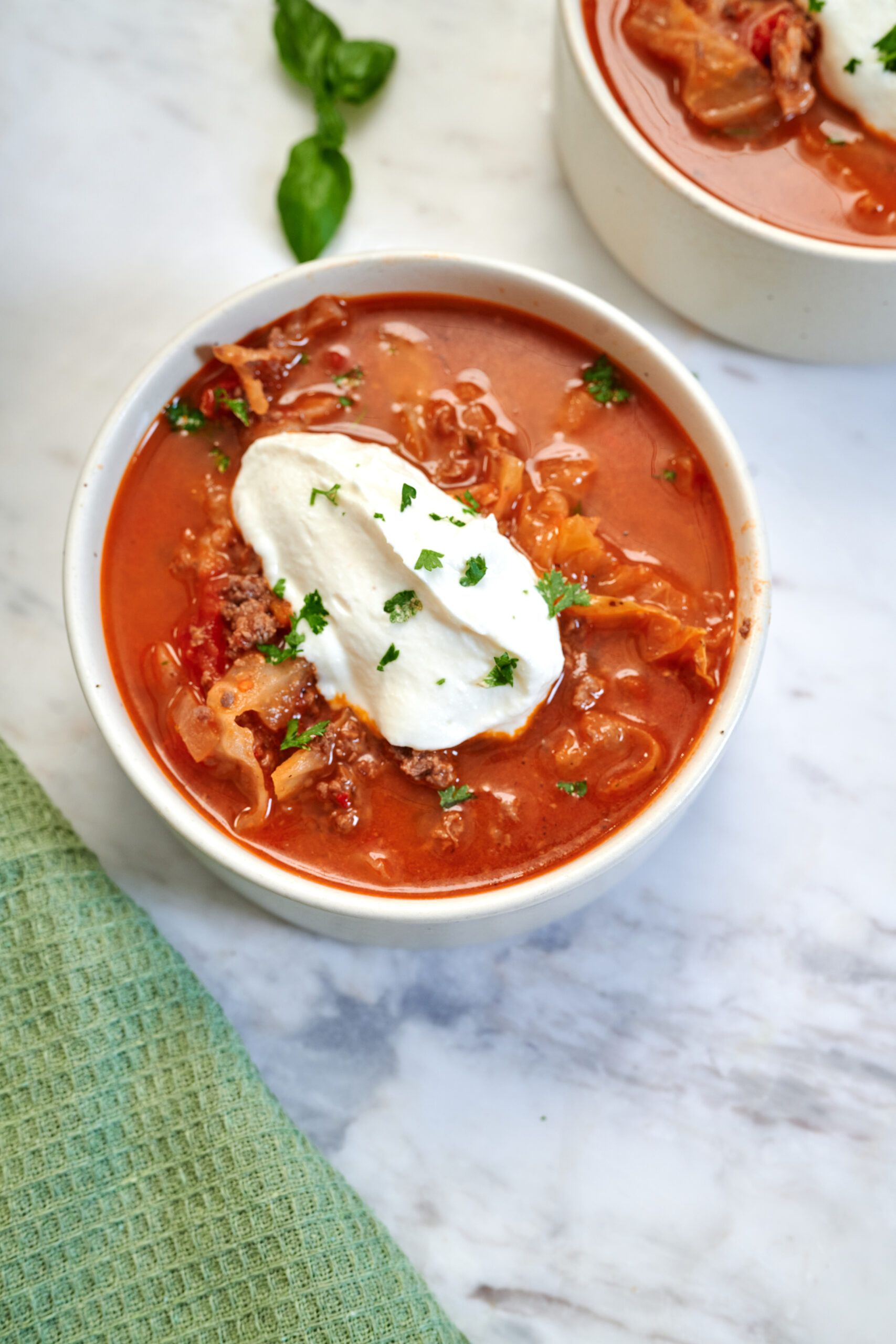 High-Protein Cabbage Lasagna Soup 2 Bowl of High-Protein Cabbage Lasagna Soup topped with creamy cottage cheese and chopped parsley.